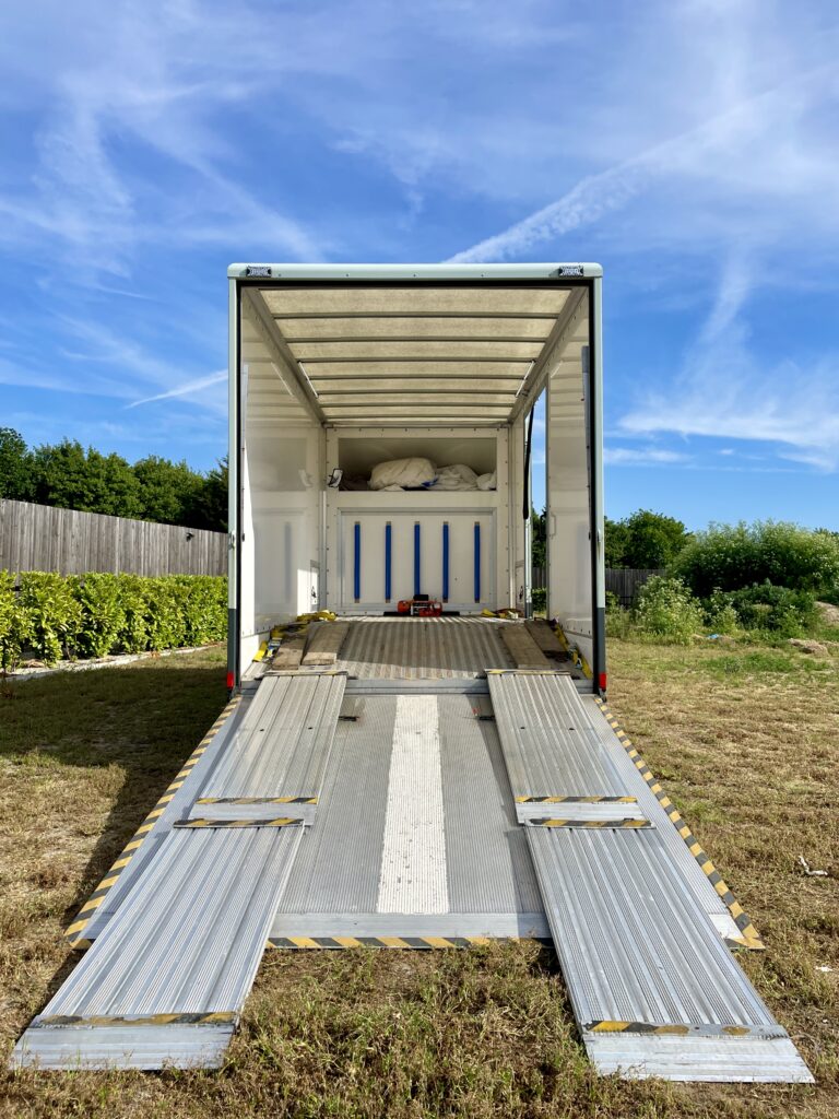Van for transporting classic cars showing beavertail mechanism for safe transport